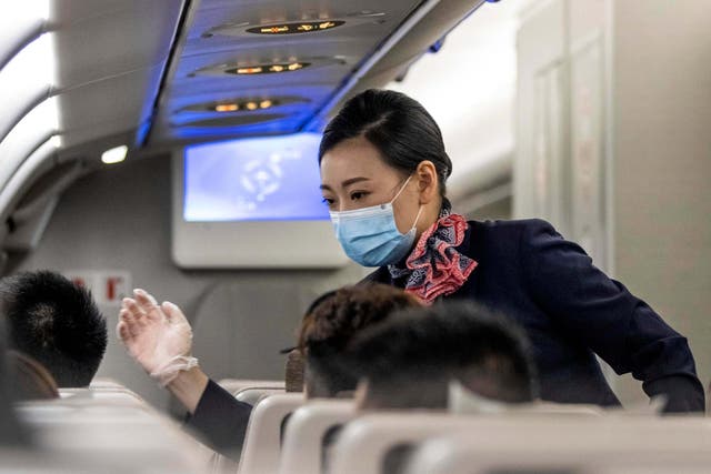 A Chinese flight attendant takes temperatures on a flight from Shanghai to Guangzhou in June