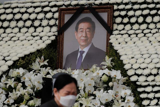 A mourner walks by a memorial altar for Park in Seoul