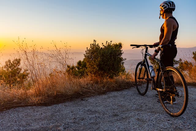 A cyclist watches the sun set in Greece