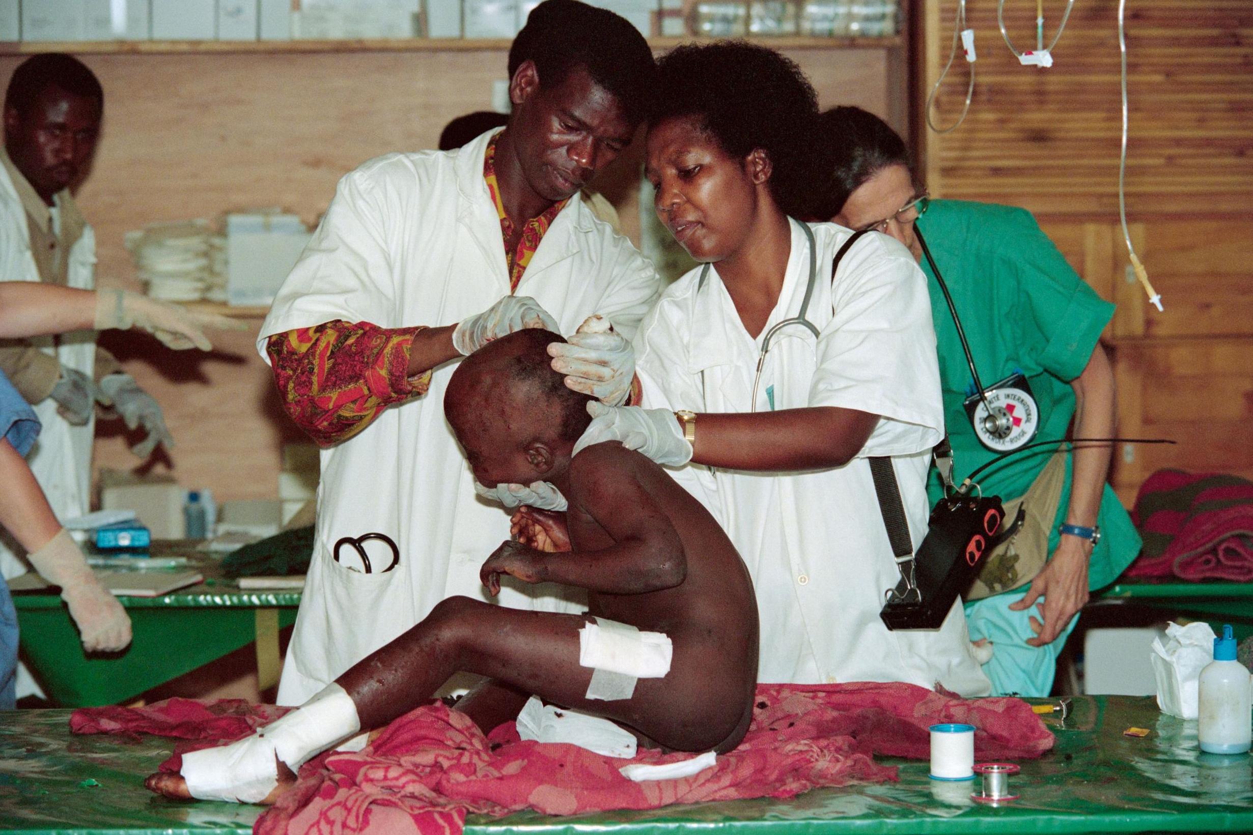 A girl covered in shrapnel wounds is treated at Kigali Red Cross hospital in 1994, one of eight injured in a shell blast