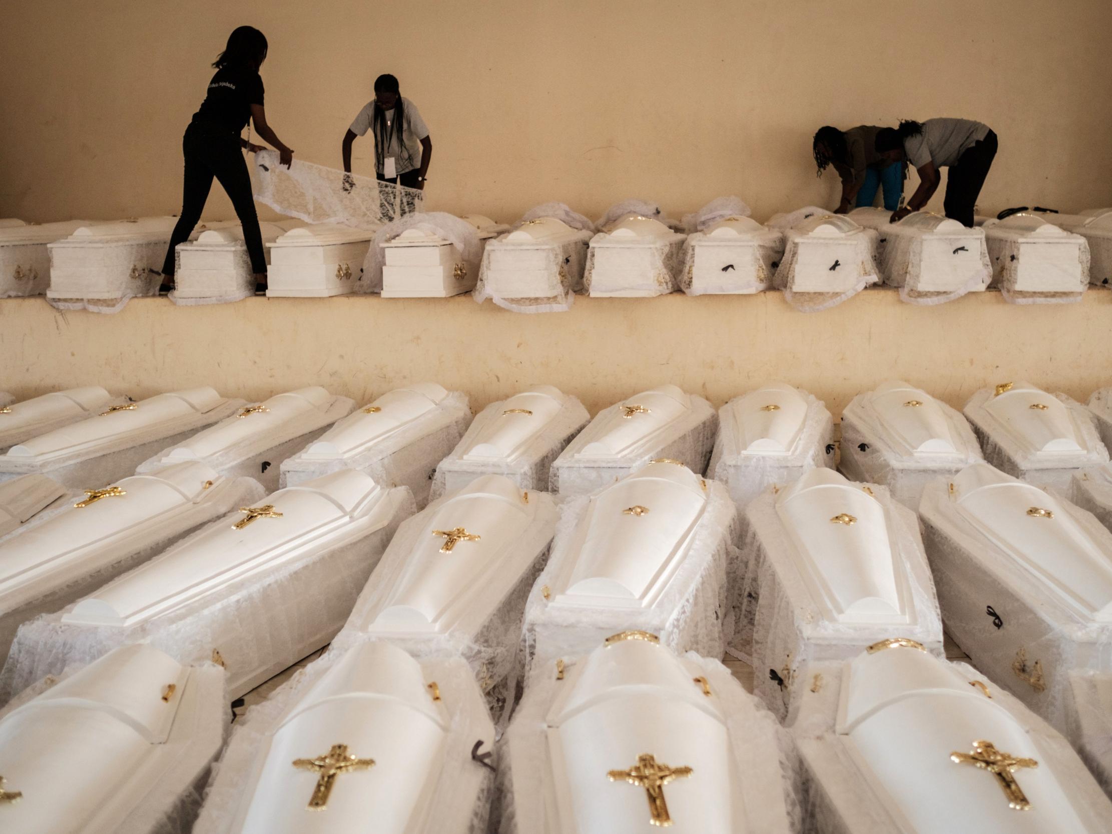 Coffins containing the newly discovered remains of 84,437 victims of the 1994 Rwandan genocide are prepared before a funeral ceremony held in Kigali in 2019