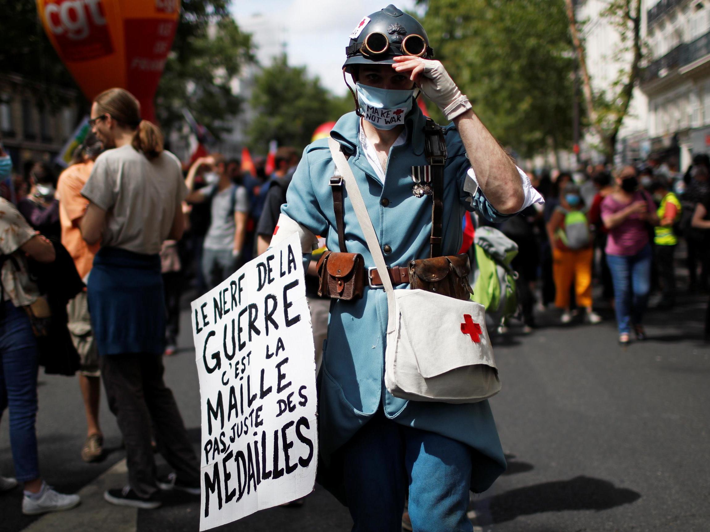 French health workers attend a demonstration on the Bastille Day in Paris to urge the French government to improve wages and invest in public hospital in the wake of the coronavirus