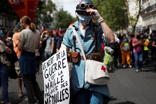 French health workers attend a demonstration on the Bastille Day in Paris to urge the French government to improve wages and invest in public hospital in the wake of the coronavirus