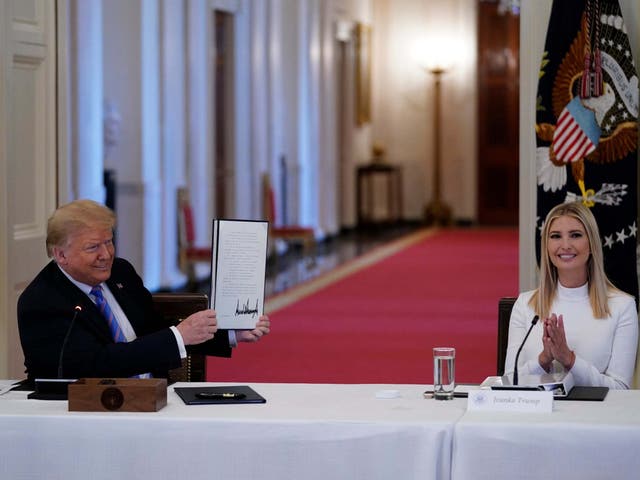 Ivanka Trump, right, applauds as President Trump holds a signed executive order during a meeting with the American Workforce Policy Advisory Board, in June. A new White House-backed ad campaign aims to encourage people who are unemployed or unhappy in their jobs or careers to "find something new"