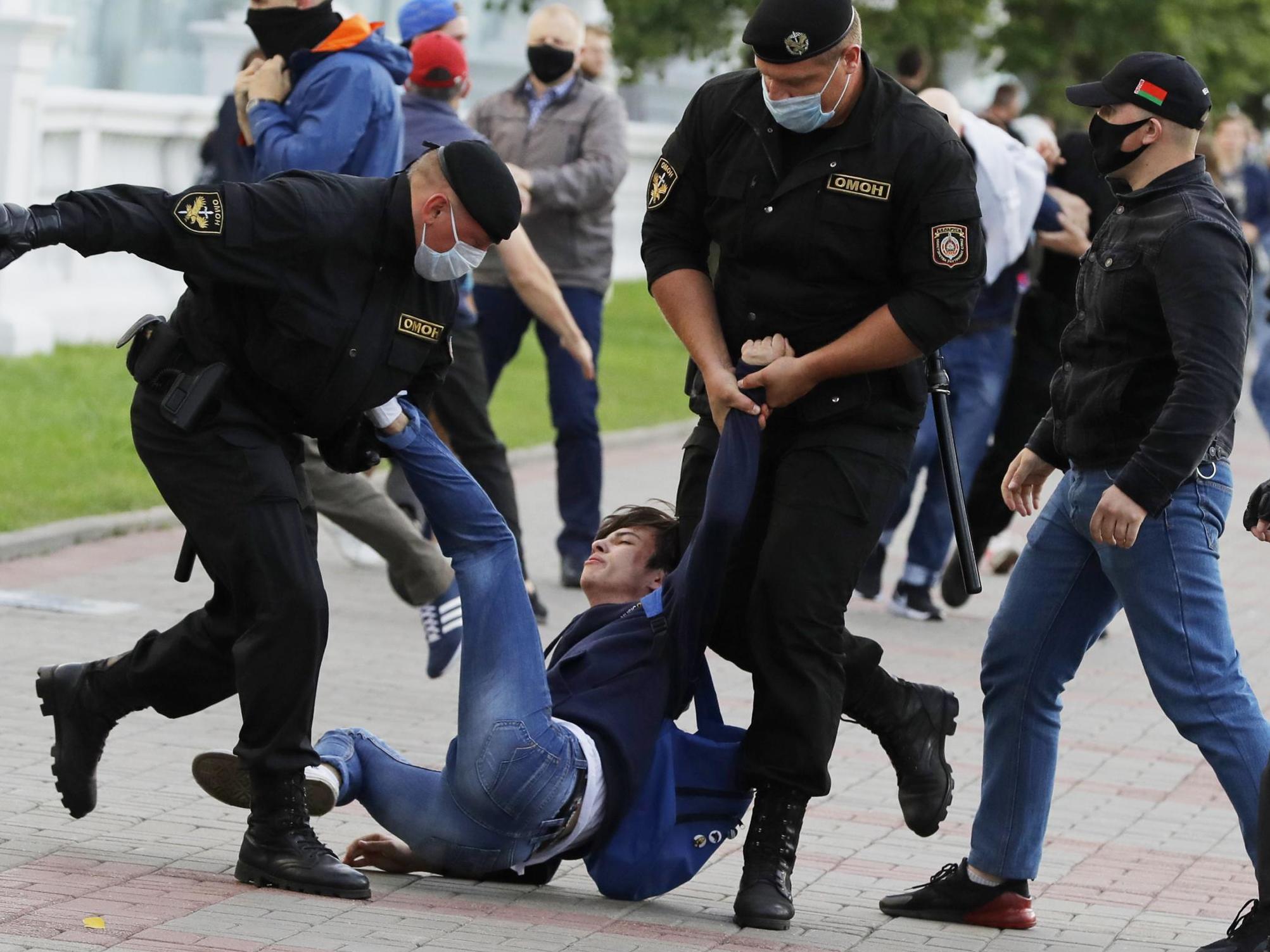 Minsk police detain a protester during a rally against the removal of opposition candidates from the presidential elections