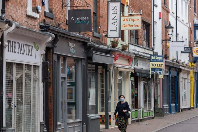 A woman wearing a face mask walks along a steeet of closed shop in Leicester where localised coronavirus lockdown restrictions have been in place since 29 June