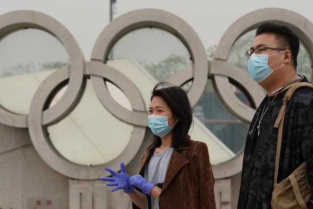 A couple walks past the Olympic Park in Beijing, China