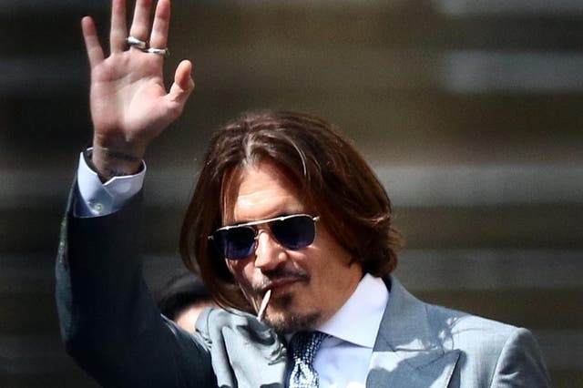 Johnny Depp waves as he leaves the High Court in London