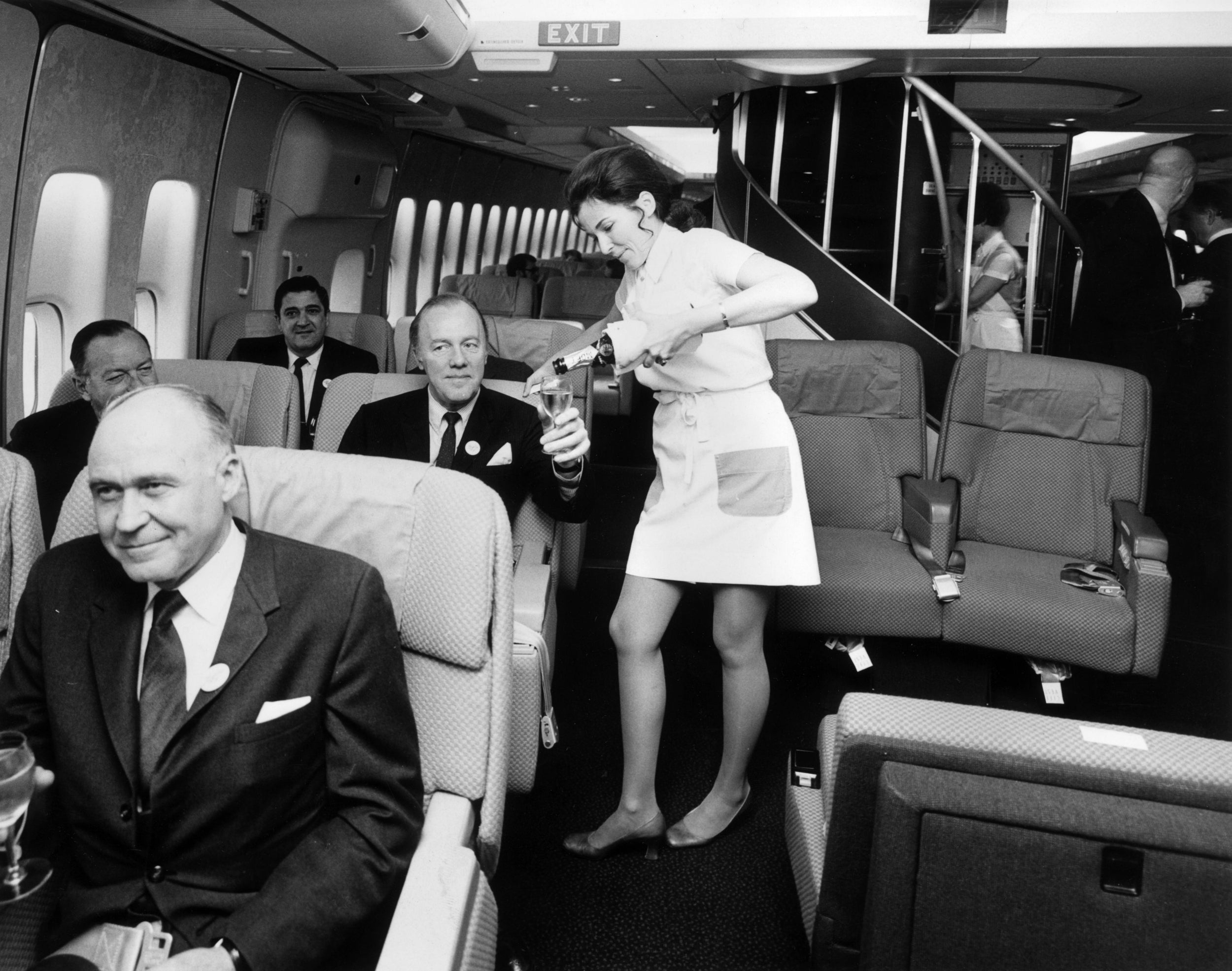 A Pan Am air hostess serving champagne in a Boeing 747