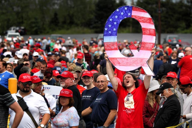 A Trump supporter holds the QAnon logo up at during a rally in Pennsylvania in 2018