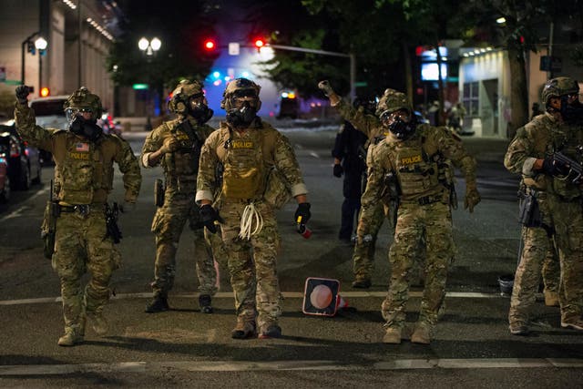 Federal law enforcement officers, deployed under the Trump administration's new executive order to protect federal monuments and buildings, face off with protesters against racial inequality in Portland, Oregon, U.S. July 18, 2020.