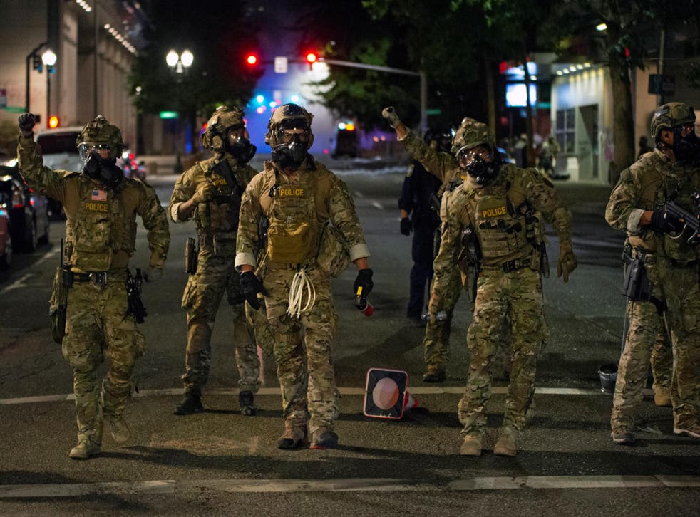 Federal law enforcement officers, deployed under the Trump administration's new executive order to protect federal monuments and buildings, face off with protesters against racial inequality in Portland, Oregon, U.S. July 18, 2020.