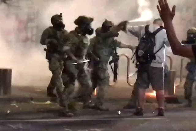 A man is sprayed by a police officer during a protest against racial inequality in Portland, U.S., July 18, 2020, in this still image obtained from a social media video.