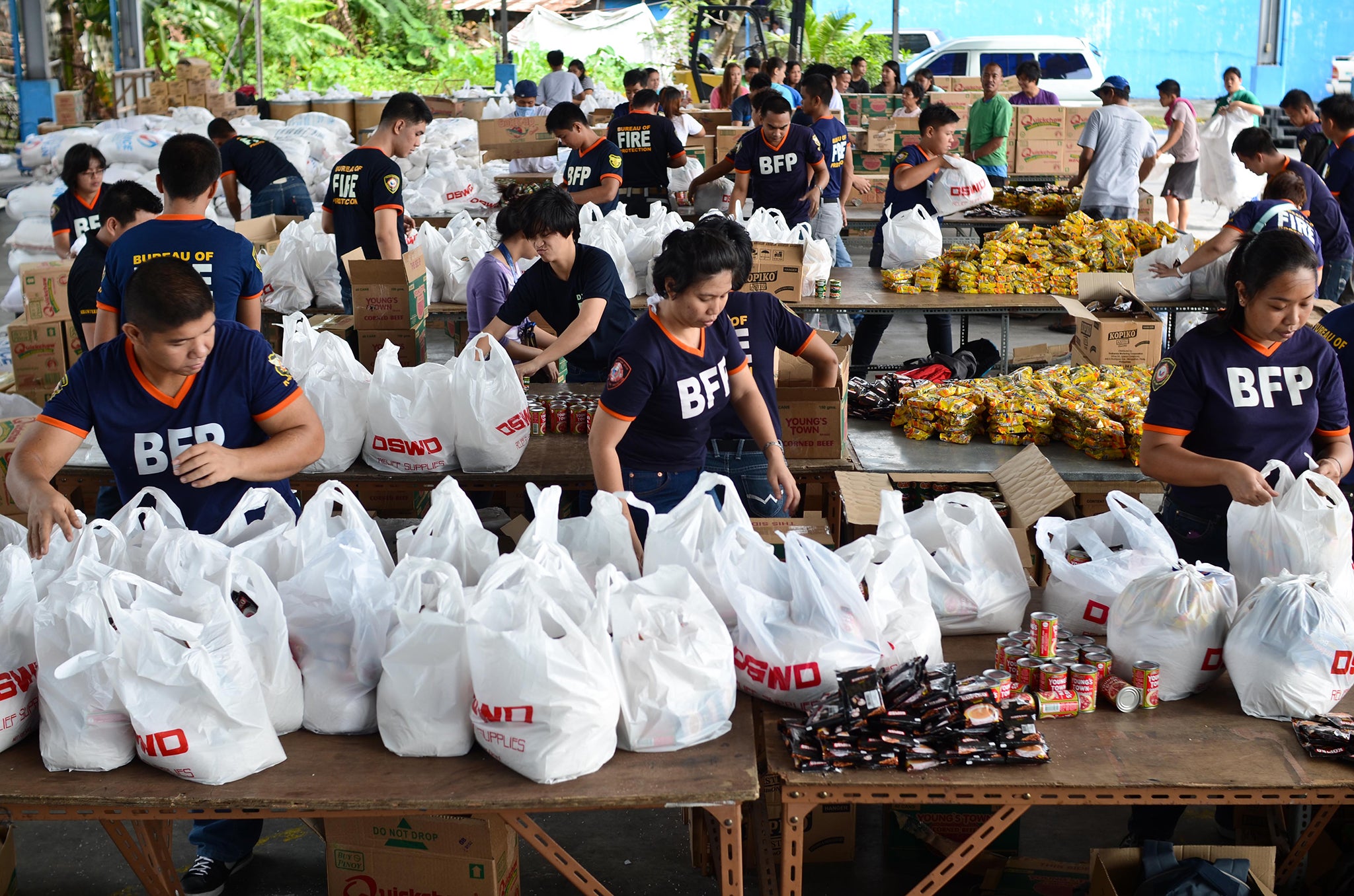 Bureau of Fire Protection volunteers pack relief goods bound for hard-hit areas of the southern Philippines