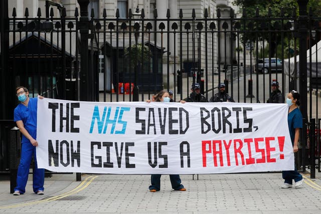 Nurses who work at central London hospitals protest with placards outside Downing Street