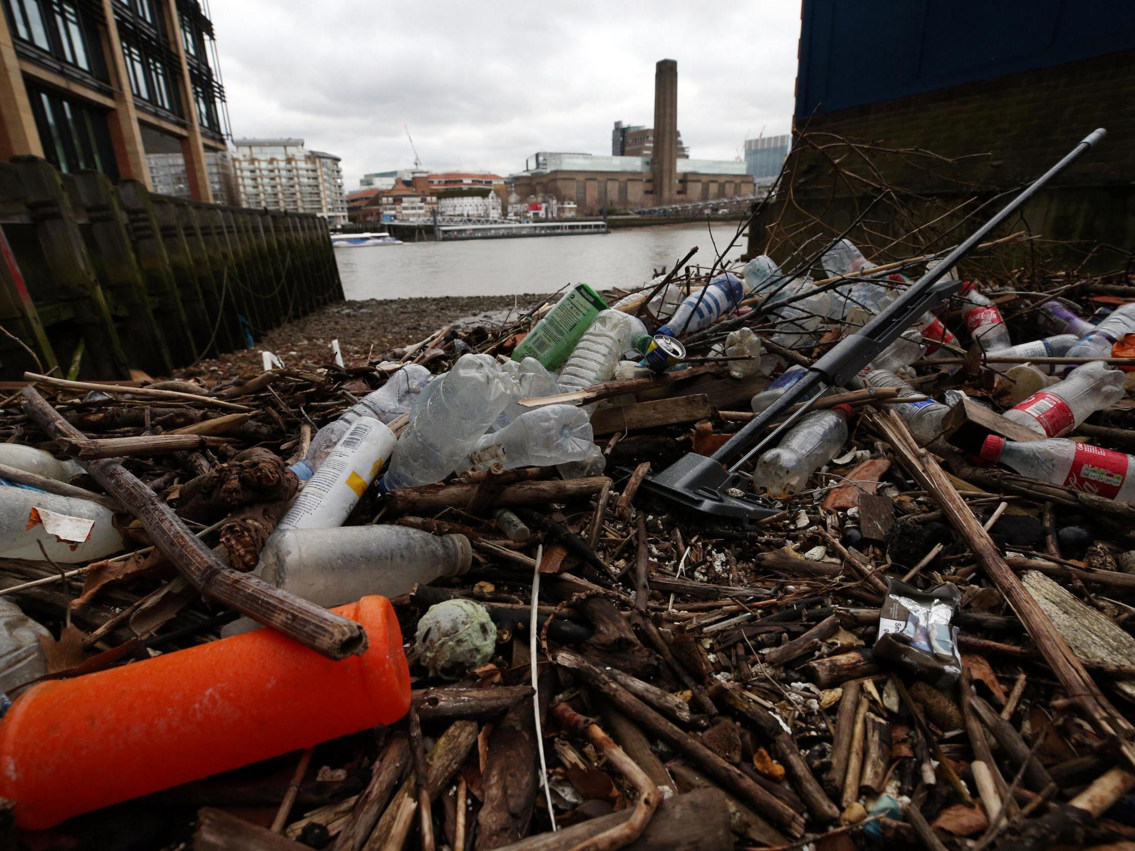 Plastic bottles and other waste litter the shore of the River Thames at Queenhithe Dock, London.