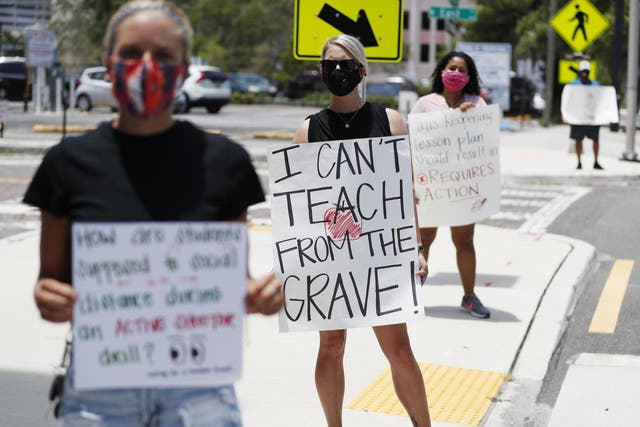 Middle school teacher Brittany Myers (centre) stands in protest in front of the Hillsborough County Schools District Office in Tampa, Florida, where teachers and administrators are rallying against the reopening of schools