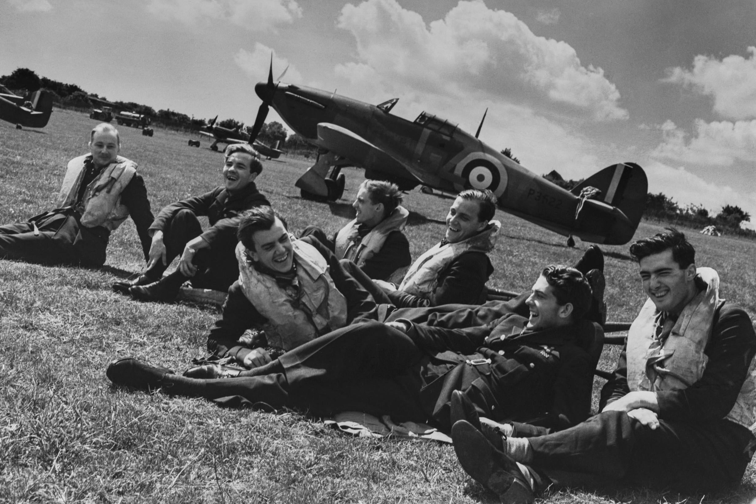 Pilots relax on the grass beside their Hawker Hurricane Mk1 fighters during the Battle of Britain at RAF Hawkinge near Folkestone