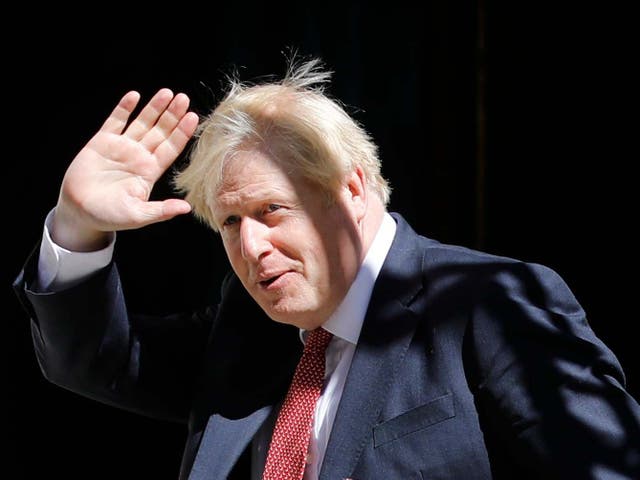 Boris Johnson waves from 10 Downing Street after leading his first face-to-face cabinet meeting on coronavirus