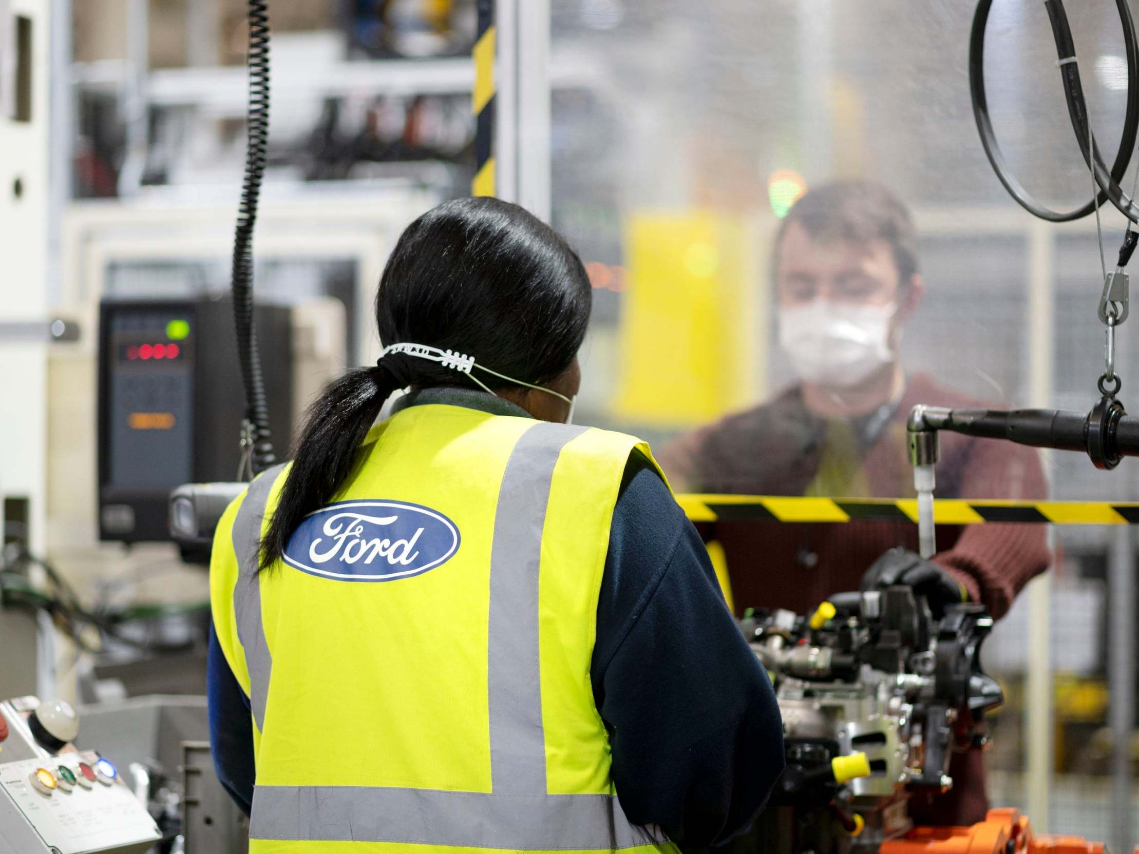Workers wearing masks and separated by a screen at Ford's Dagenham Engine Plant in Essex