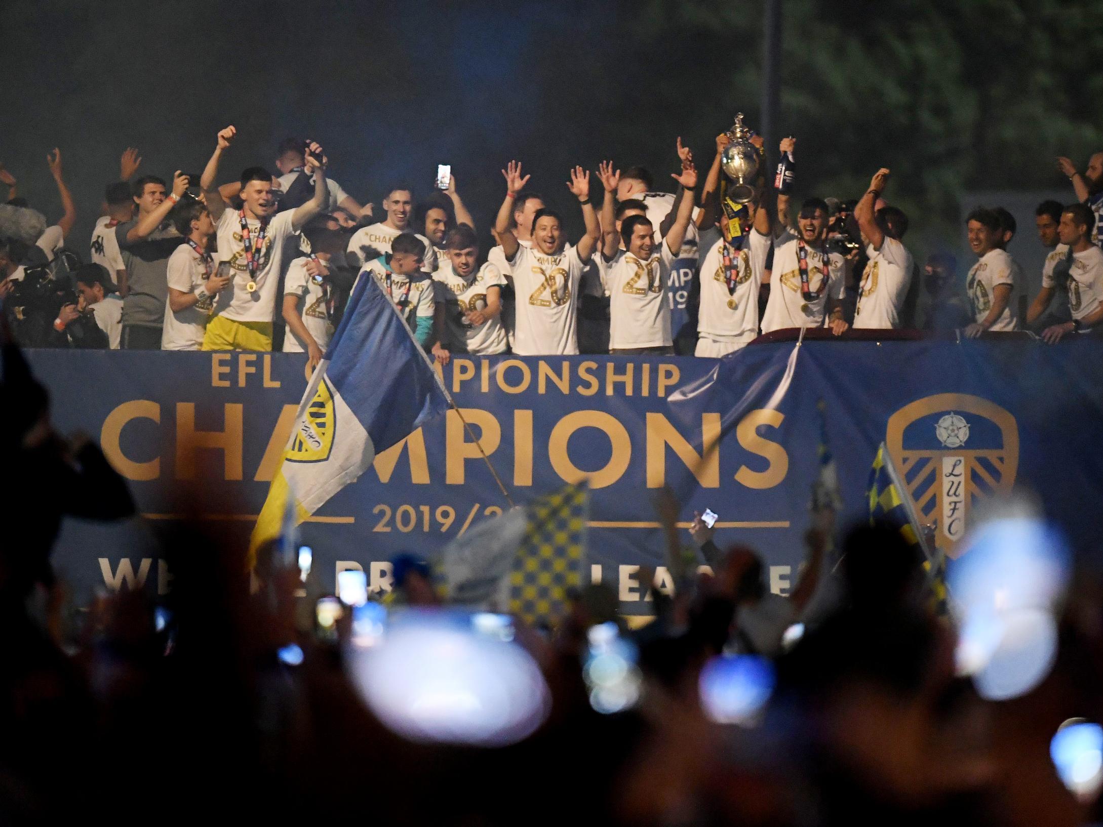 Leeds players and staff lift Championship trophy on a bus outside Elland Road (Getty)