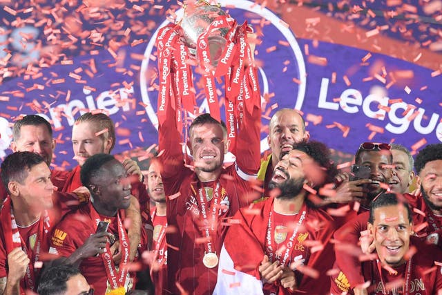 Jordan Henderson lifts the Premier League trophy after Liverpool's success