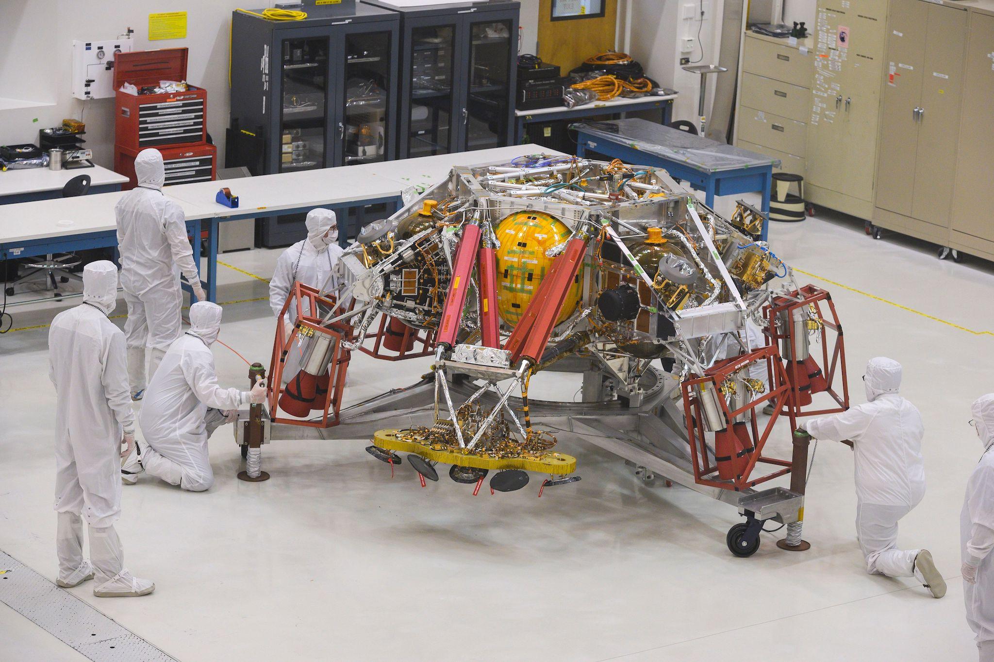 NASA engineers and technicians reposition the Mars 2020 spacecraft descent stage December 27, 2019 during a media tour of the spacecraft assembly area clean room at NASA's Jet Propulsion Laboratory in Pasadena, California