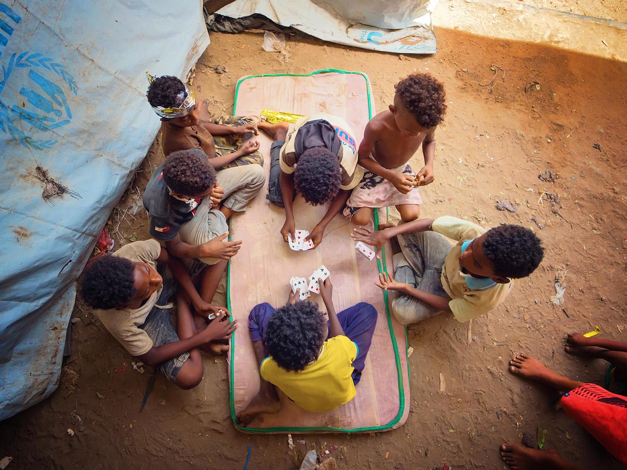 Children play cards in a camp in Yemen
