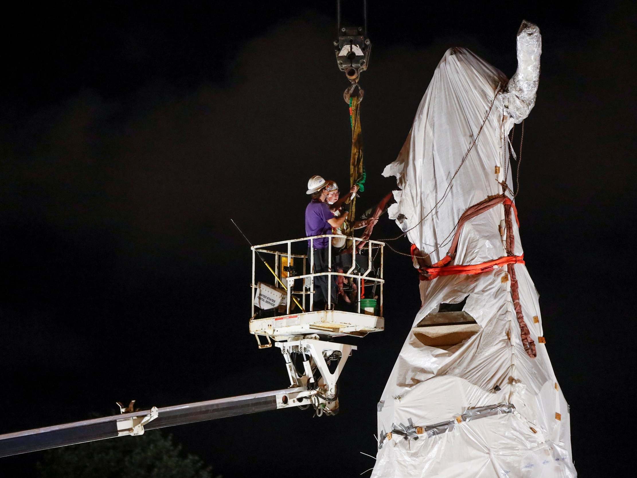 Crew members remove Christopher Columbus statue from the Grant Park in Chicago