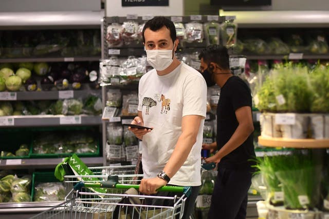A shopper wearing a face mask in a supermarket in east London as face coverings become mandatory in shops and supermarkets in England, 24 July 2020.