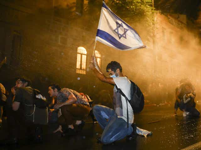 Israeli police use a water cannon to disperse people during a protest against Netanyahu in Jerusalem