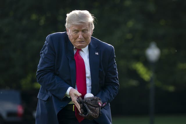 Donald Trump catches a baseball thrown by former New York Yankees Hall of Fame pitcher Mariano Rivera on the South Lawn of the White House on July 23, 2020