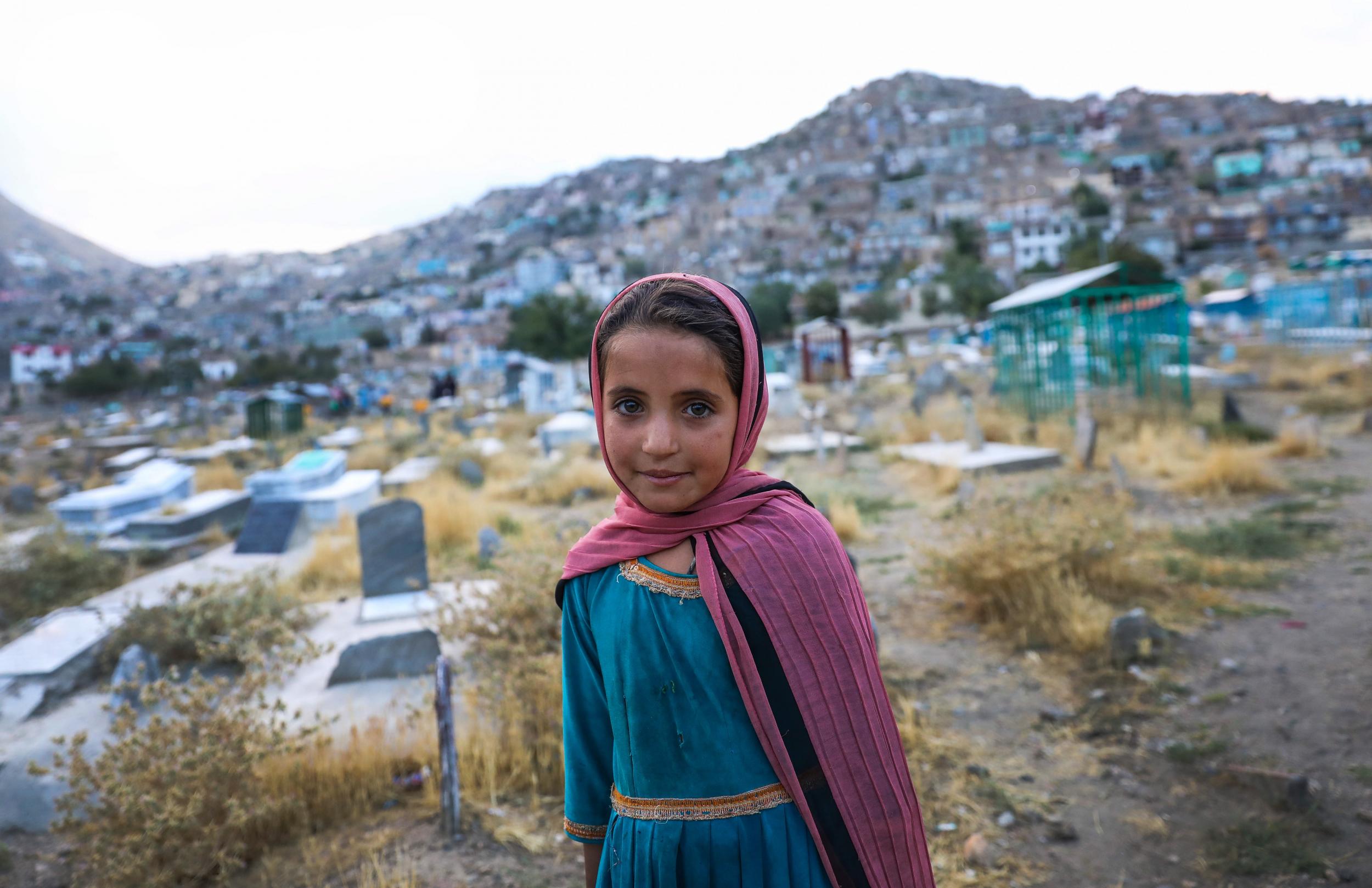 Salema, 7, sells water in Kart-e Sakhi cemetery in Kabul, 17 July. EPA/HEDAYATULLAH AMID
