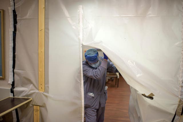 A health worker walks through a Covid-19 patient area in Richmond, Texas on 15 July. CDC projects estimate deaths will rise to 170,000 in August.