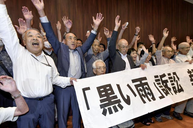 A group of plaintiffs and supporters celebrate during a meeting following the court ruling in Hiroshima, western Japan