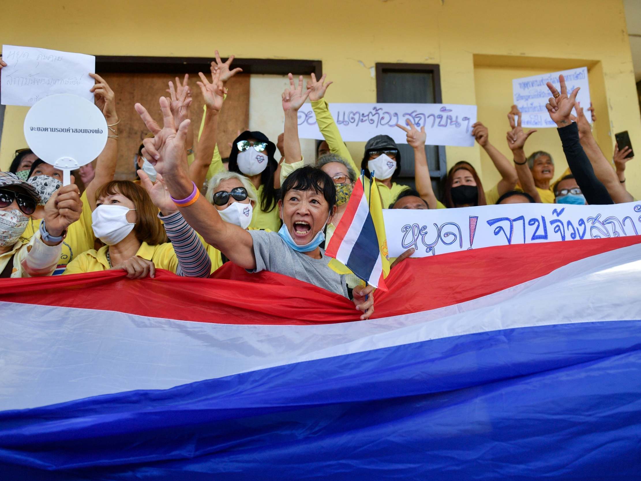 Pro-royalist supporters wearing yellow shirts wave a Thai national flag attend a rally to show their support for the monarchy