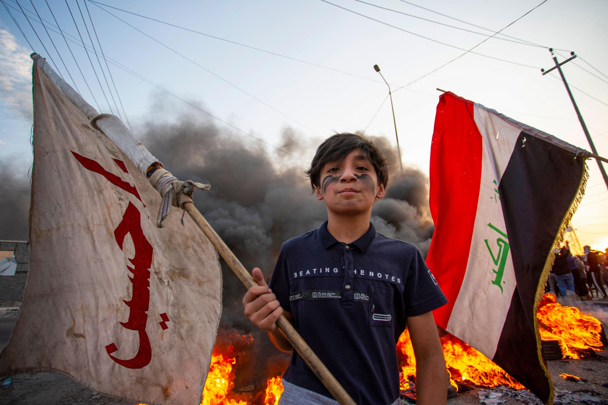 A demonstrator waves a flag during a protest in the southern city of Basra