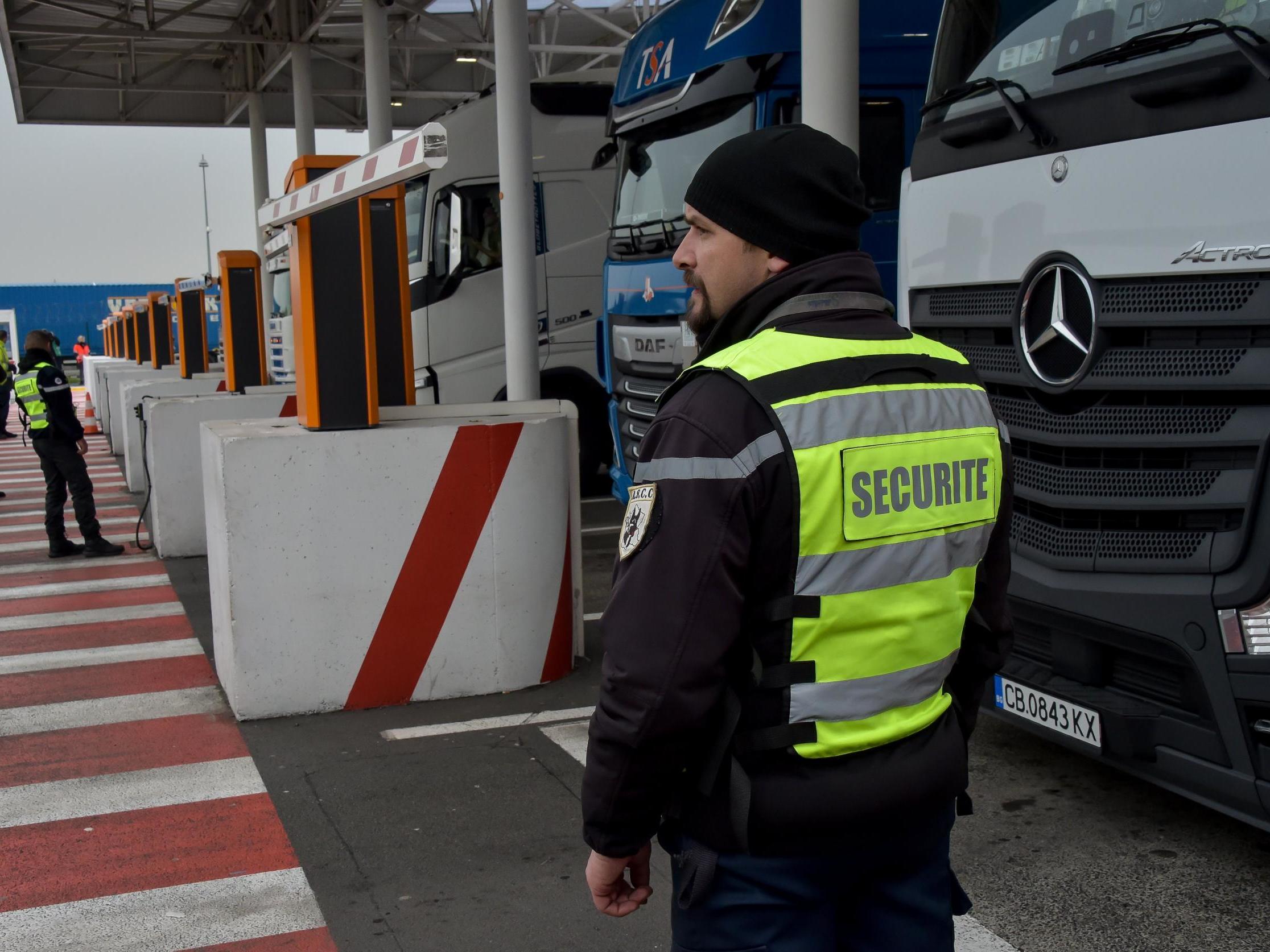 A security agent controls lorries at the Coquelles Eurotunnel border post in 2019