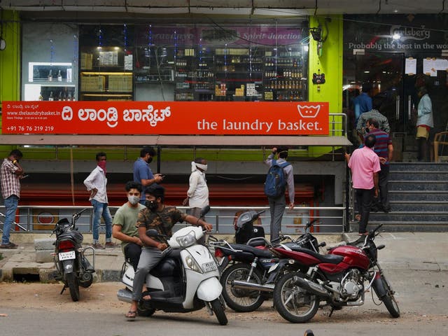 People line-up outside a Bangalore liquor store to make a last minute purchase ahead of a new lockdown