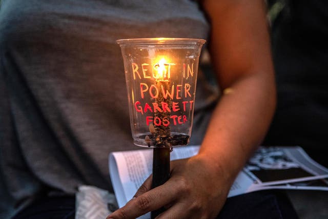 An attendee holds a candle at a vigil for Garrett Foster in downtown Austin, Texas. Foster, who was armed and participating in a Black Lives Matter protest, was shot and killed after a chaotic altercation with a motorist who allegedly drove into the crowd