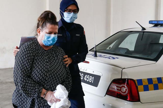 British national Samantha Jones, accused of killing her husband in 2018, is escorted by a police officer as she arrives at a court in Alor Setar, in northern Malaysia, on 3 August 2020