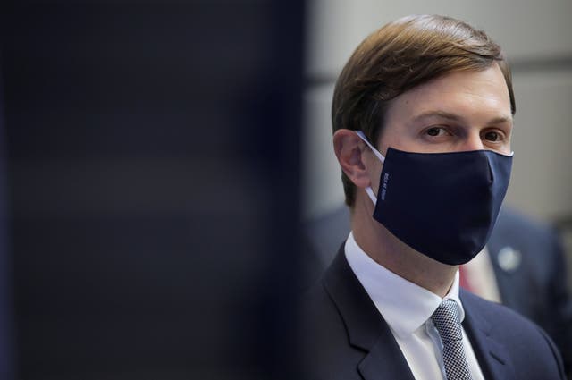 Jared Kushner watches, masked, as Donald Trump delivers a speech