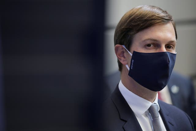 Jared Kushner watches, masked, as Donald Trump delivers a speech