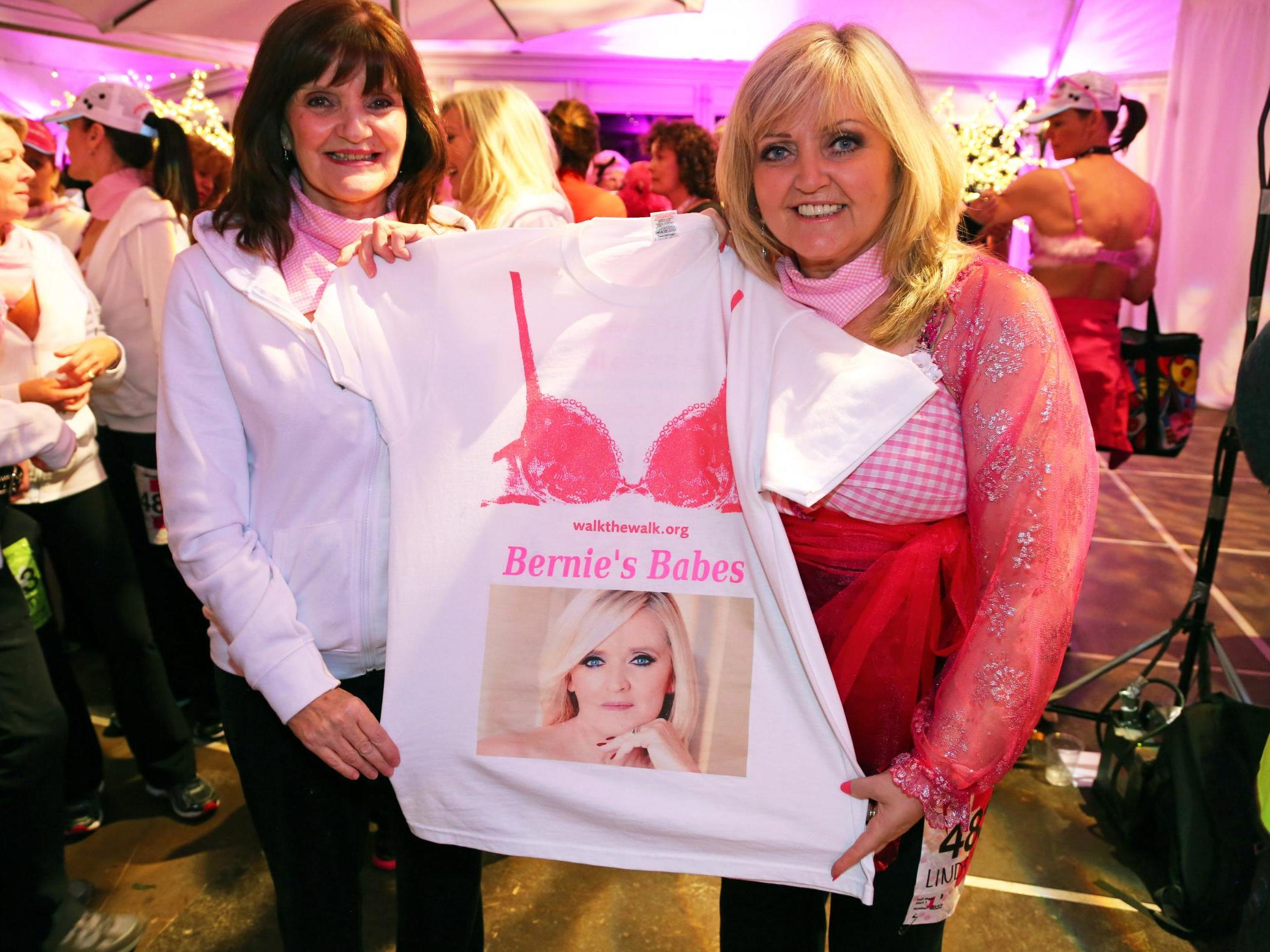 The sisters attend the Walk the Walk Moonwalk charity walk in London on 10 May 2014, holding a T-shirt showing their sister Bernie who died of breast cancer in 2013