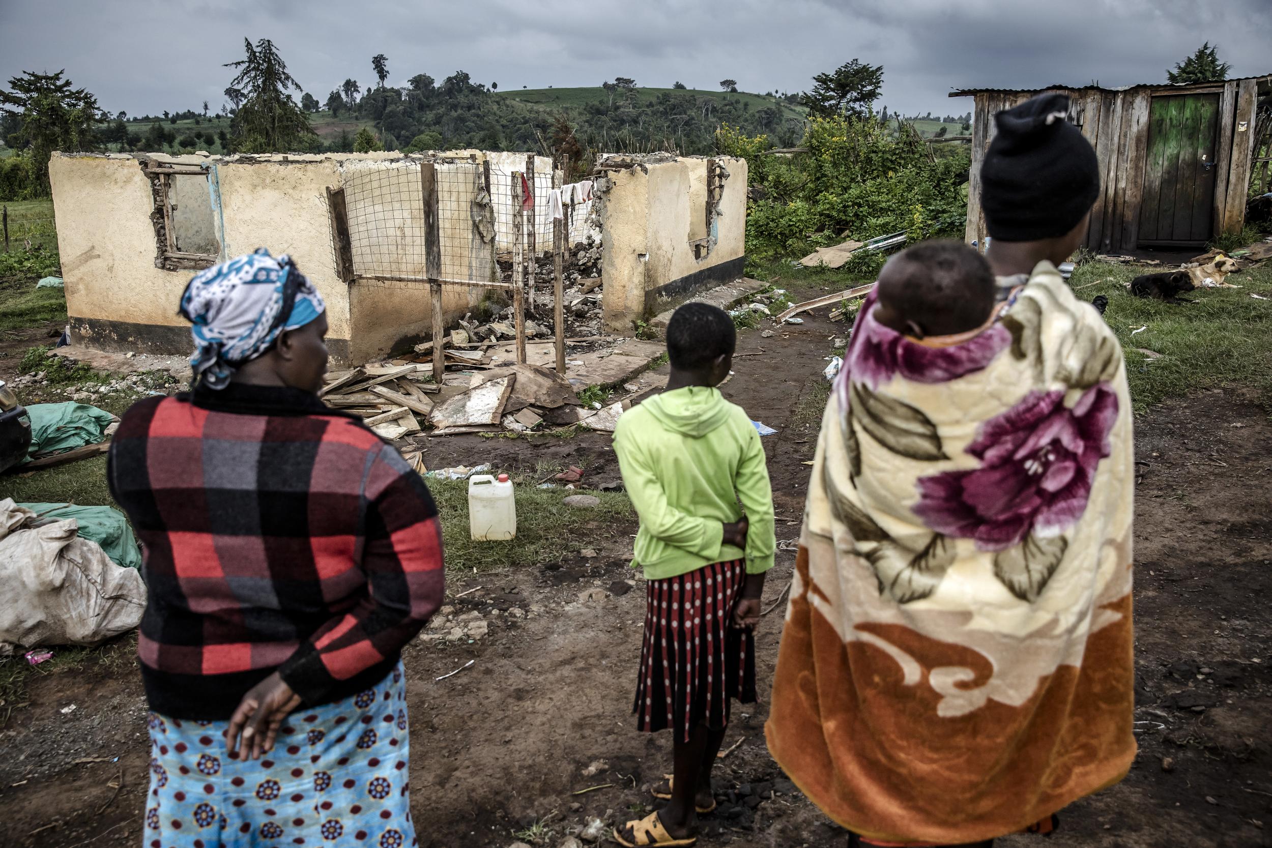 Lilian Tuimising (left) and her daughters observe what remains of their home