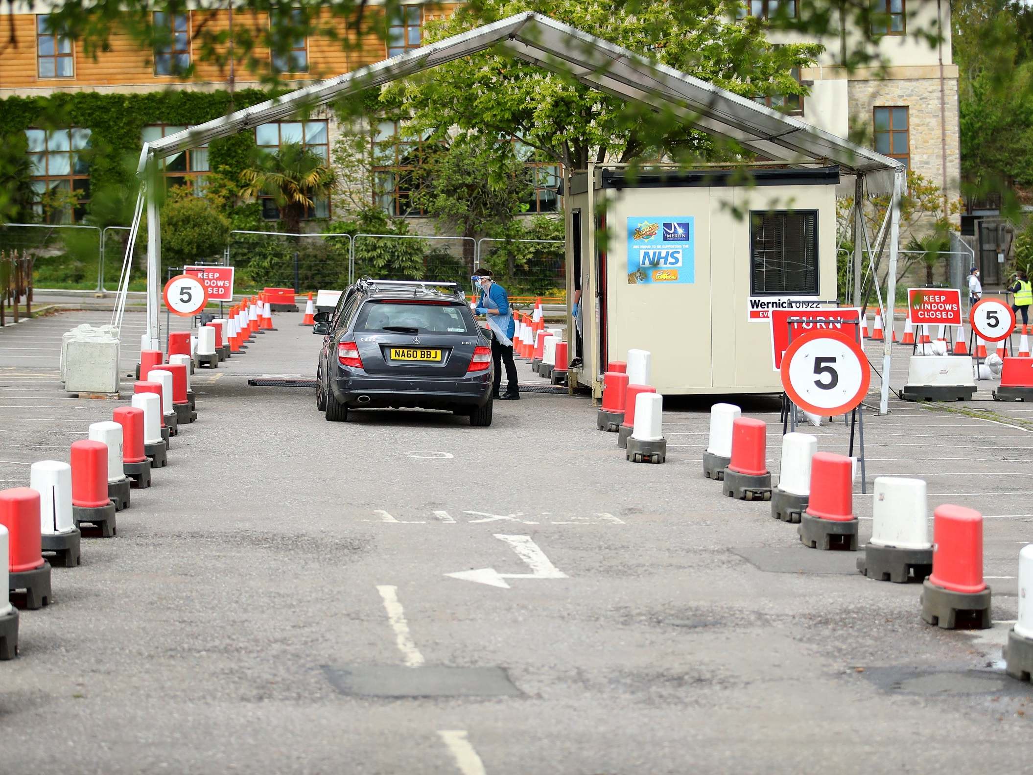 Cars are parked awaiting a swap test at a coronavirus drive-through testing centre in a car park in London