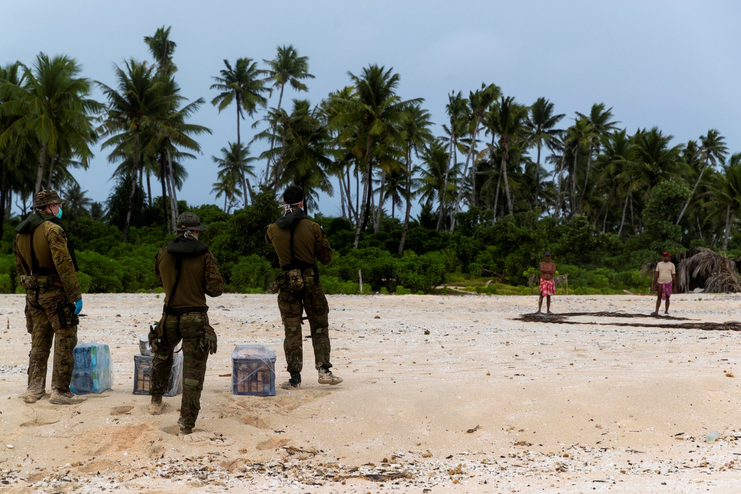 Australian army soldiers deliver food and supplies to the three stranded mariners