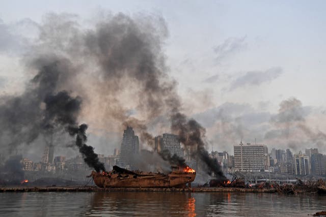 A ship in flames is pictured at the port of Beirut following a massive explosion on Tuesday
