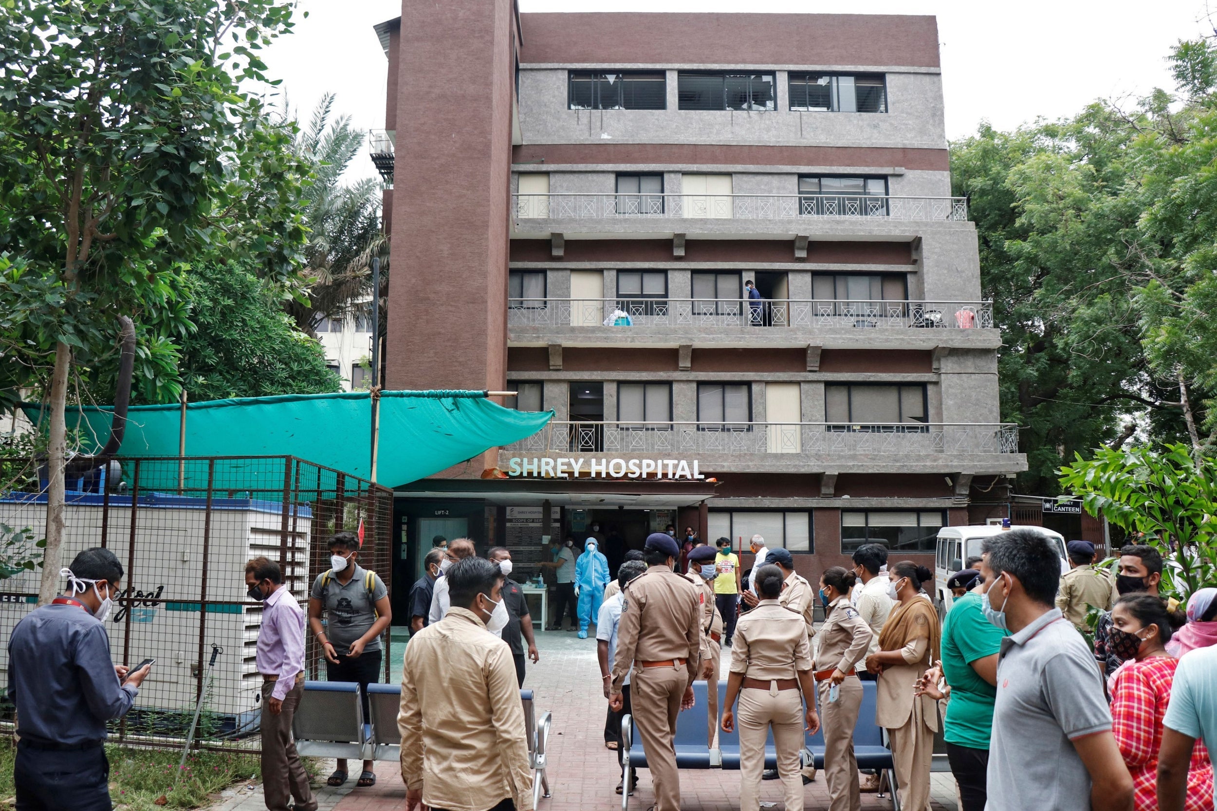 Police officers and relatives outside a hospital where a fire broke out on Thursday in Ahmedabad, India, killing eight Covid-19 patients