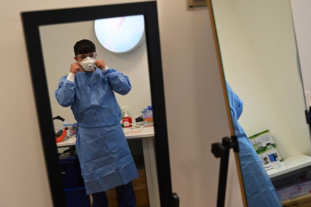 A member of staff adjusts their mask at the Intensive Care unit at Royal Papworth Hospital in Cambridge